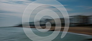 Panned image of Eastbourne seafront showing beach, buildings and sea