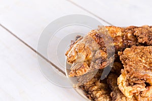 Panned pork steaks on the plate above wooden board background.