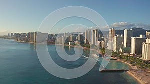 Panning aerial drone slowly flying over a colorful Honolulu Skyline while Sunset in Oahu, Hawaii with Waikiki Beach