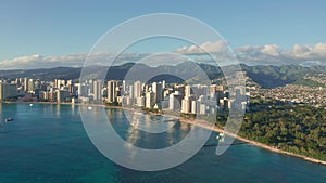 Panning aerial drone slowly flying over a colorful Honolulu Skyline while Sunset in Oahu, Hawaii with Waikiki Beach