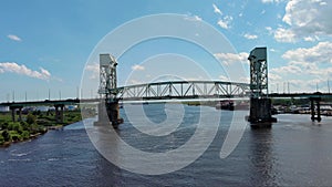 panning aerial footage of the flowing waters of Cape Fear River and Cape Fear Memorial Bridge with cars and trucks driving