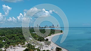 panning aerial footage of a gorgeous summer landscape at Crandon Park with vast blue Atlantic ocean, lush green palm trees