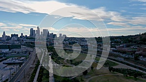 Panning aerial footage of Los Angeles State Historic Park with skyscrapers and office buildings in the city skyline and people