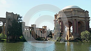 panning footage of a beautiful spring landscape at Palace of Fine Arts with a lake, lush green trees and plants