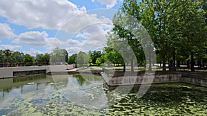 panning footage of a gorgeous spring landscape at Louis Armstrong Park with lush green trees and grass, a lake, blue sky