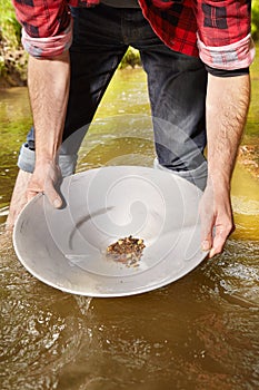 Panning of golden nuggets in creek