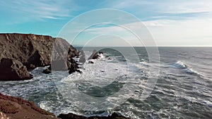 Panning right to show bluffs near bodega bay with hikers near the edge