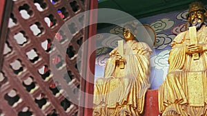 Panning shot at golden Buddhist statues in Chinese temple