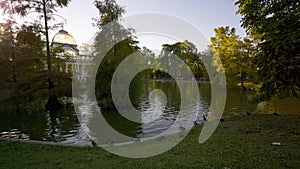 Panning shot of a sunset view of Crystal Palace or Palacio de cristal in Retiro Park in Madrid, Spain.