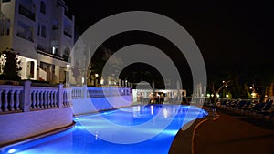 Panning of swimming pool at the luxury hotel in night illumination