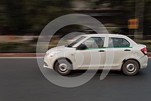 Panning technique of white car which is going somewhere at evening on the road