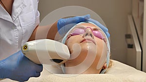 Panning up shot of doctor or therapist administering fractional skin laser treatment to resurface and rejuvenate a