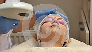 Panning up shot of doctor or therapist administering fractional skin laser treatment to resurface and rejuvenate a