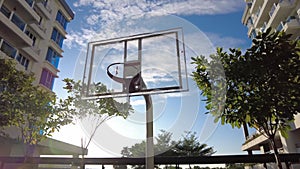 Panning view during sunrise of basketball board in an apartment residential