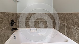 Pano Bathroom interior with drop in tub with brown tile surround