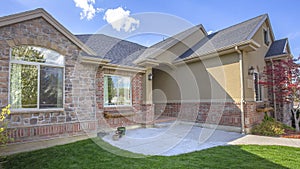 Pano Beautiful exterior of home with brick wall landscaped yard and arched entryway