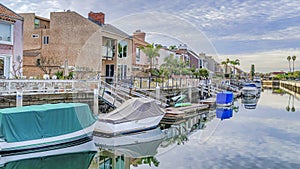 Pano Boats on docks of canal along seaside houses in Huntington Beach Califonia