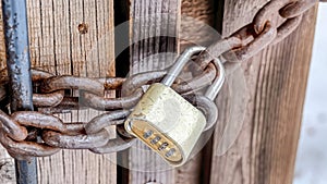 Pano Combination padlock and rusty iron chain securing the door of outdoor bathroom