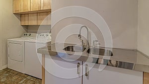 Pano Double basin sink and curved faucet with cabinet inside functional laundry room