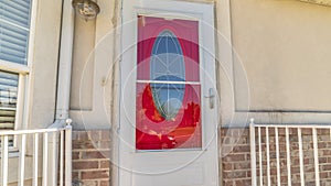 Pano Exterior of a home with decorative oval glass paned vibrant red front door