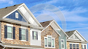 Pano Exterior view of homes with gable roofs stone brick and wooden siding walls