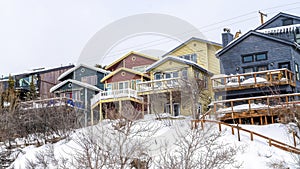 Pano Family homes on a snowy mountain residential area against white sky in winter