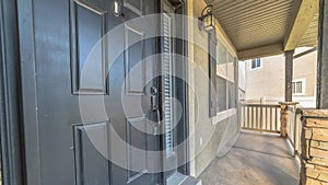 Pano frame Home exterior view with gray front door sidelight and front porch on a sunny day