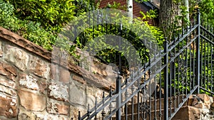 Pano frame Outdoor staircase with stone steps and black metal railing against a fence