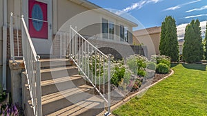 Pano Home with stairs going uo to the red front door against brick and concrete wall