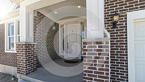 Pano Home with steps and portico leading to the white front door between sidelights