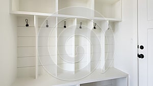 Pano Interior of a white mudroom with white garage door and wooden flooring