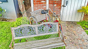 Pano Old wooden bench and bicycle at the front lawn of home in Long Beach California