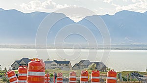 Pano Road under construction with blurry view of homes lake and mountain against sky