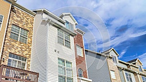 Pano Townhouses on a sunny day setting with balconies overlooking scenic skyscape