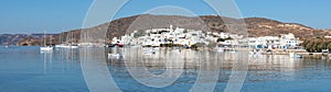 Panorama of Adamas village with boats and mountain reflecting in Milos bay