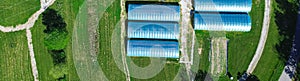 Panorama aerial view high tunnel greenhouse on large grassy vacant land of large commercial farm in rural Ozarks aera photo