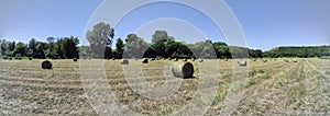 Panorama of an agriculture field with a twisted haystack