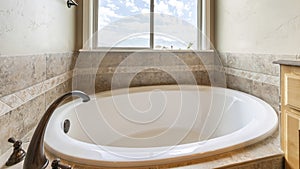 Panorama Alcove bathtub with antiqued marble tiles and deck mounted widespread faucet