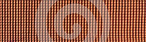 panorama of antique clay red roof tiles of an ancient house, close-up of the repeating wave pattern of orange clay roof tiles