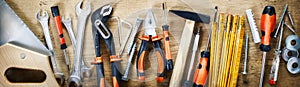 Panorama banner of assorted hand tools on wood