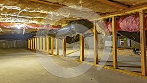 Panorama Basement or crawl space with upper floor insulation and wooden support beams