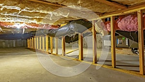 Panorama Basement or crawl space with upper floor insulation and wooden support beams photo