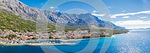 Panorama of Baska Voda town with harbor against mountains in Makarska riviera, Dalmatia, Croatia photo