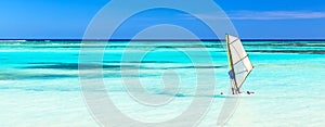 Panorama of beautiful beach with windsurfer on the sea against blue sky background