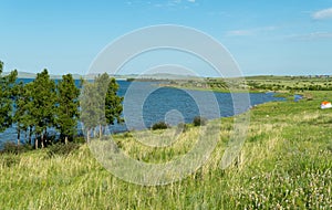 Panorama of a beautiful lake with hilly shores. sunny summer day