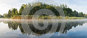 Panorama. Beautiful landscape. Dawn on the river with foggy haze on a background of green forest