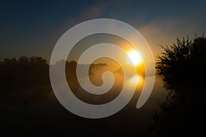 Panorama of beautiful misty lake coast at sunrise moment