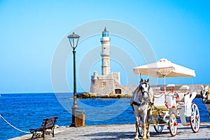 Panorama of the beautiful old harbor of Chania with the amazing lighthouse, mosque, venetian shipyards, at sunset, Crete. photo