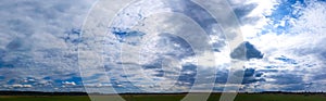 Panorama of Beautiful summer landscape. Countryside with road on the field, green grass, trees and dramatic blue sky with fluffy