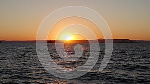 Panorama of beautiful sunset by the sea. Military ships at sea at sunset
